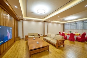 Un salón amplio con una mesa de centro de madera, sofás y un televisor.