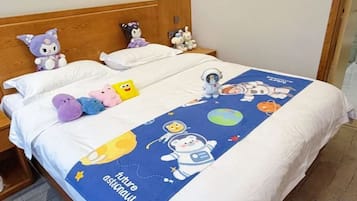 Una cama con una colcha temática del espacio y peluches.