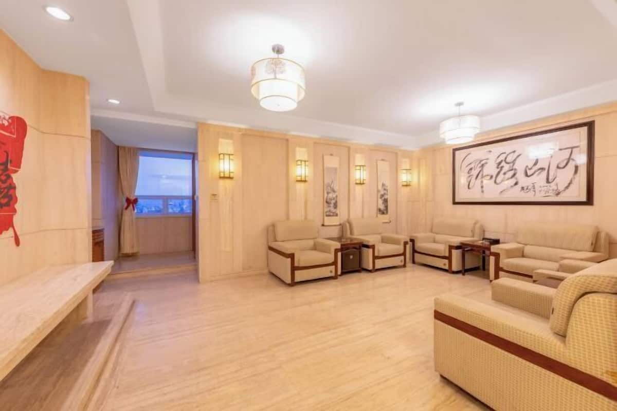 A modern living room with a sofa set, a bench, and wall-mounted lighting.