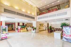 Amplio espacio interior con techo alto, una recepción y una escalera que sube a un nivel superior.