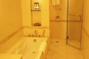 A bathroom with a bathtub, a glass shower enclosure, and a towel rack. - Haolaiwan Hotel (Luoding)