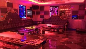 A room with a checkered floor, two ornate sofas, a glass coffee table, and decorative screens with floral designs. - Haolaiwan Hotel (Luoding)