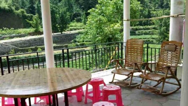 A terrace with a round table and four rocking chairs, surrounded by a white railing. - Qingliangzhai Liu Yinong Family Lodging (Wuhan)