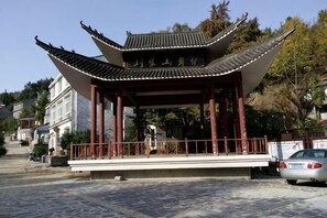 A traditional Chinese pavilion with a tiled roof and red pillars.