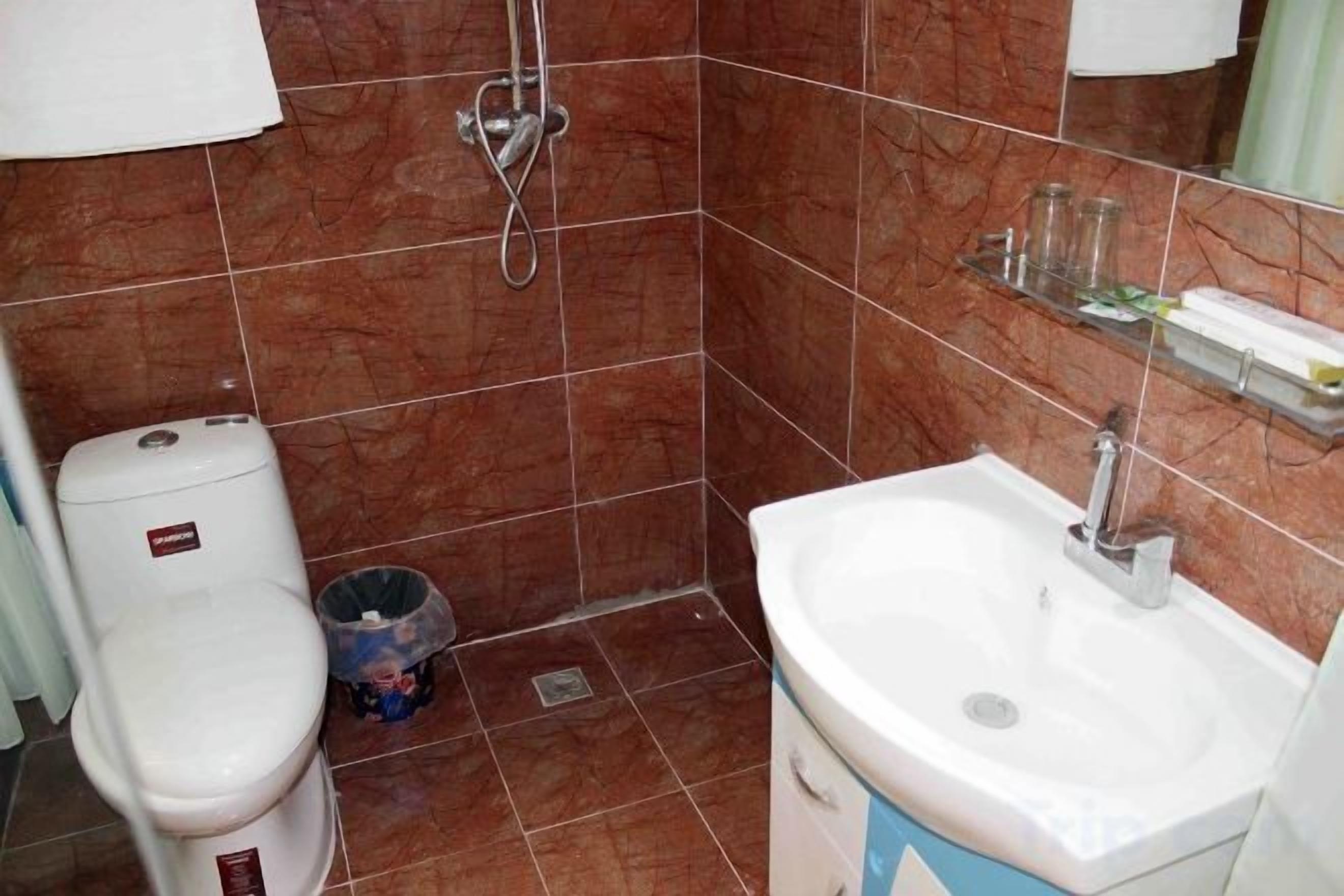 A bathroom with a toilet, sink, and shower.