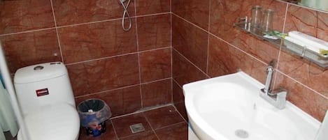 A bathroom with a toilet, sink, and shower.