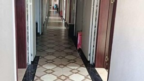 A long, narrow hallway with patterned floor tiles and doors on either side. - Haosen Hotel (Urumqi)