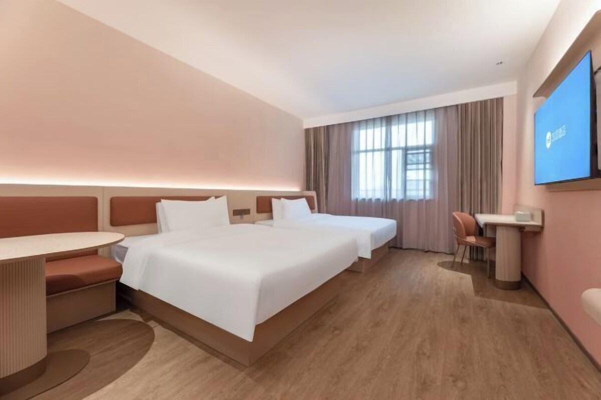 Hotellihuone, jossa on suuri sänky, työpöytä ja televisio.