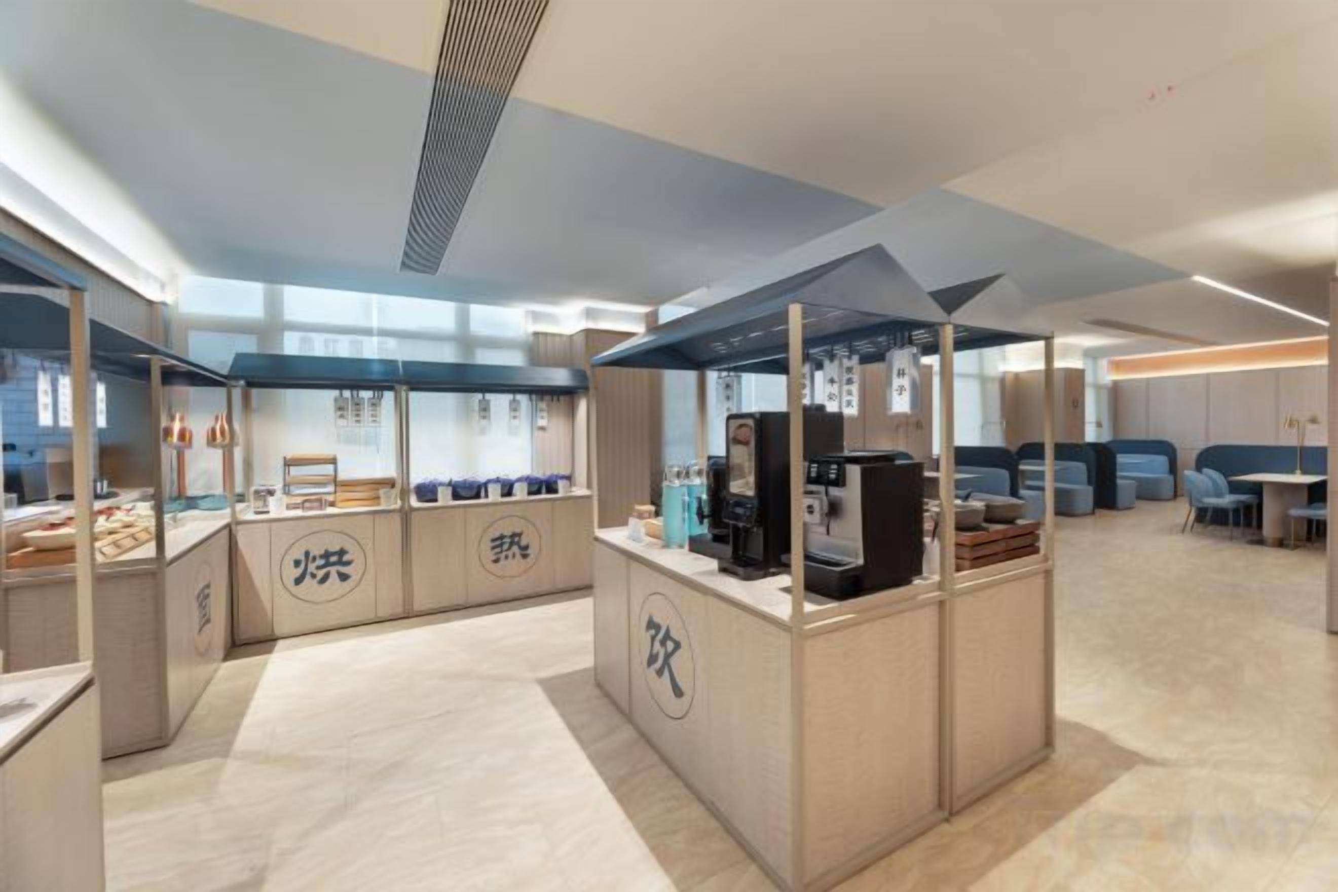 A modern interior with a central counter, seating area, and a kitchen.