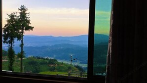 Vista desde una ventana a un paisaje montañoso con cielo despejado.