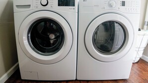 Zwei Waschmaschinen mit Frontlader stehen nebeneinander in einem Waschraum.