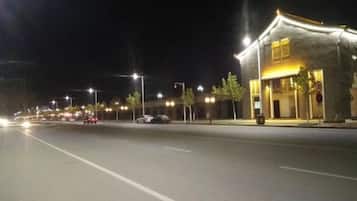 Una calle de noche con un edificio a la derecha.