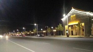 Une scène de rue nocturne avec un bâtiment sur la droite.