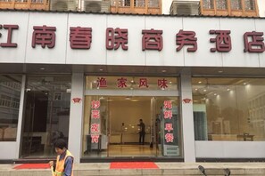 A hotel entrance with signage indicating services like 'fish and wine' and 'night market.' - Daishan Xiushan Hotel (Daishan)