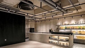 A modern kitchen with a central island, stainless steel appliances, and a display of bottles. - Ingu Stay (Yangyang)