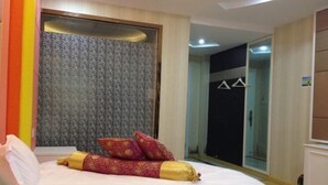 A hotel room with a bed, a mirror, and a wardrobe. - NANYUAN INN (Cixi Sanbei East Road) (Cixi)