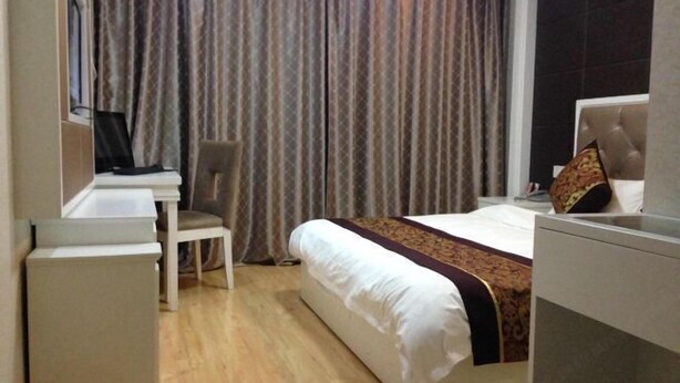 A hotel room with a bed, a desk, a chair, and a television. - NANYUAN INN (Cixi Sanbei East Road) (Cixi)
