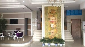 A lobby with a chandelier, a reception desk, and a floral wall decoration. - NANYUAN INN (Cixi Sanbei East Road) (Cixi)