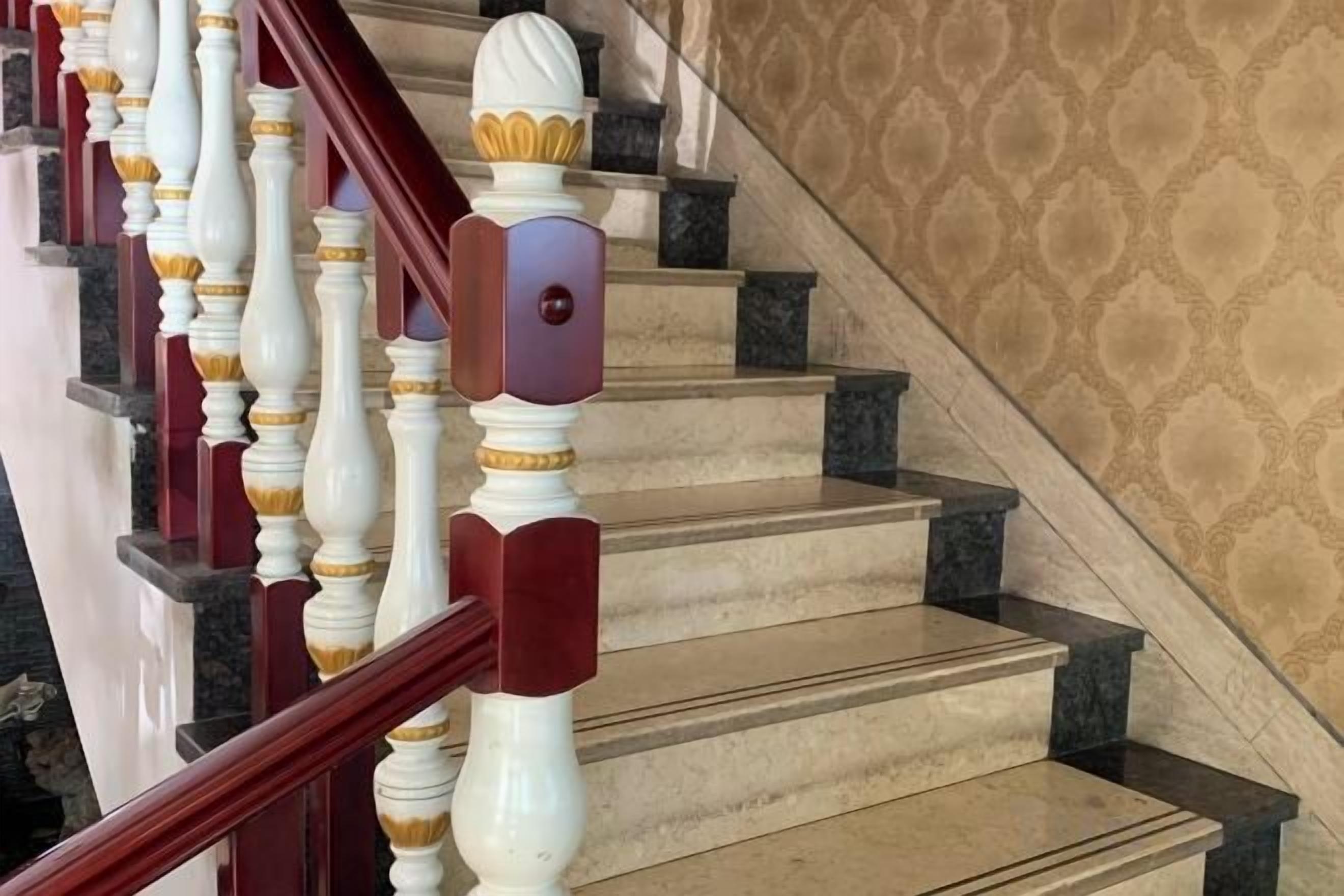 A staircase with marble steps and a red handrail.
