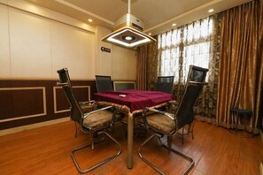 A conference room with a round table, four chairs, and a ceiling light fixture.
