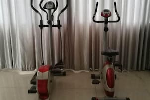 Duas bicicletas ergométricas em um espaço com um fundo de cortina.