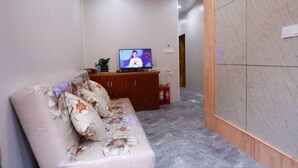 Una sala de estar moderna con un sofá, un televisor y un mueble de madera.