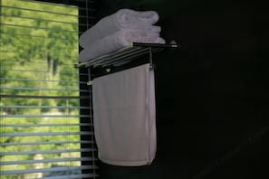 A towel rack with folded towels against a window with blinds. - Two mus of Banvilla Tangquan Meisu (SHISHE Store) (Tonglu)