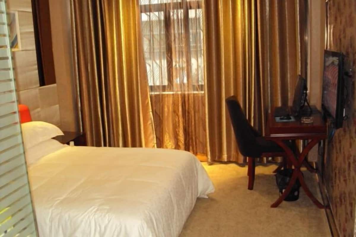Een hotelkamer met een bed, een bureau en een stoel.