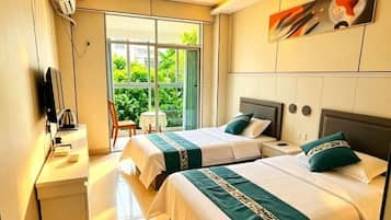 Una habitación de hotel con dos camas, un escritorio, una silla y un televisor.