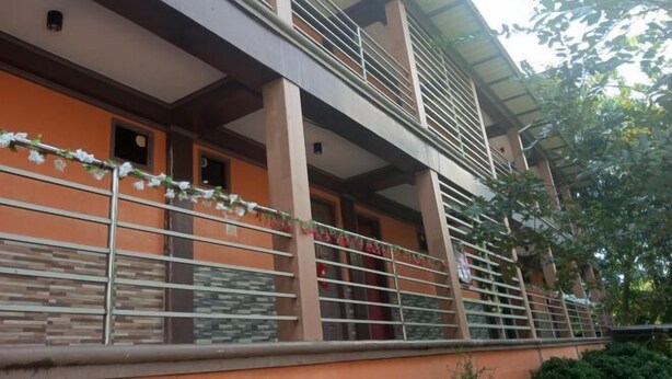 A multi-story building with balconies, railings, and a tiled facade. - Idmat Inn (Davao City)