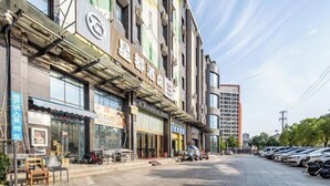 A multi-story building with a row of shops on the ground floor. - Youth City Mini Hotel (Wuhan Institute of Engineering Science and Technology) (Wuhan)