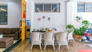 Una sala de estar moderna con un sofá, una mesa de comedor con sillas y una pequeña zona de cocina.