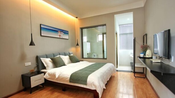 Un dormitorio con cama, mesita de noche y televisor.