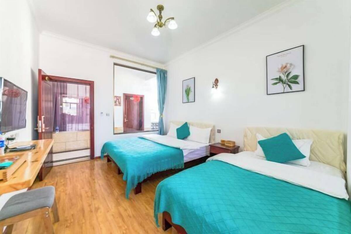 Une chambre d’hôtel avec deux lits, un bureau et une chaise.