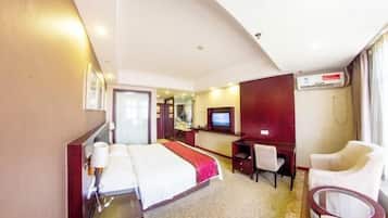 Een hotelkamer met een bed, bureau, stoel en een televisie.