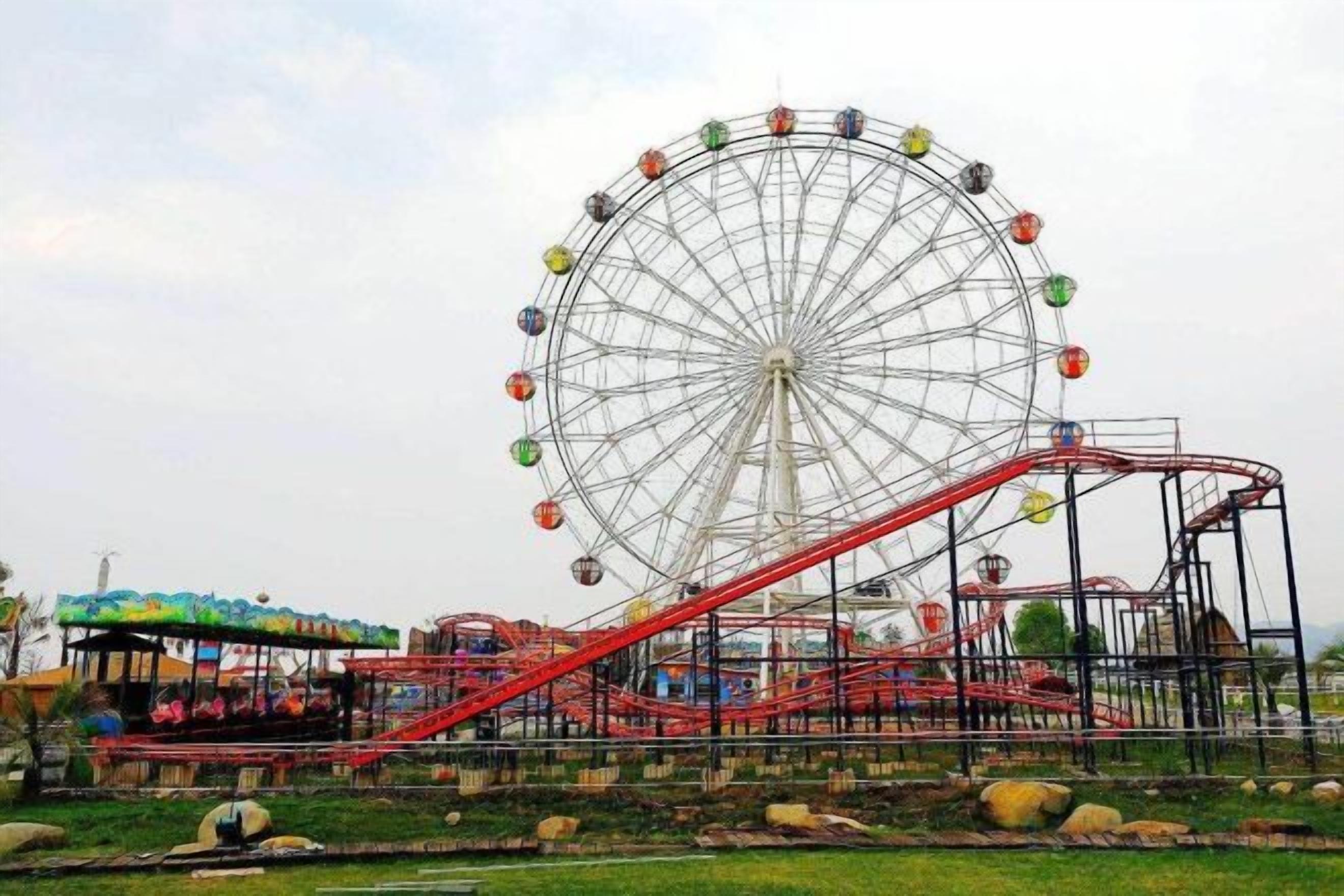 A large Ferris wheel with a red roller coaster adjacent to it.