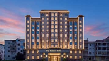 A multi-story hotel with a prominent entrance and a sign reading 'City Business Hotel.'