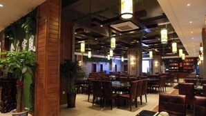 A restaurant with wooden pillars, hanging pendant lights, and potted plants. - TianchengBusinessHotel (Luxi)