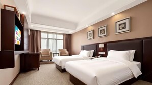 A hotel room with two beds, a desk, a TV, and a window with curtains. - TianchengBusinessHotel (Luxi)