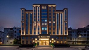 A multi-story hotel with a prominent entrance, large windows, and a sign reading 'City Business Hotel.' - TianchengBusinessHotel (Luxi)