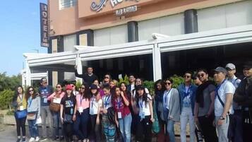 Un grupo de personas de pie frente a un hotel con un letrero que dice "HOTEL".