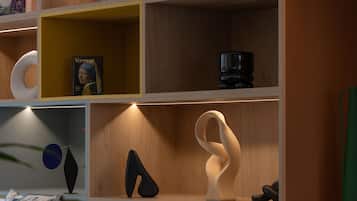 A shelf with a book titled 'Vermeer,' a black object, and abstract sculptures.