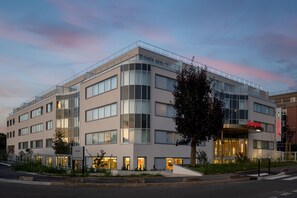 A modern hotel with a flat facade, multiple windows, and a visible entrance. - Hampton By Hilton Paris Charles De Gaulle Airport (Roissy-en-France)