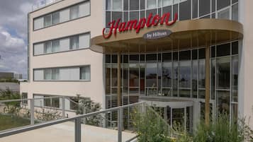 Un bâtiment moderne sur lequel on peut voir une enseigne bien visible indiquant « Hampton by Hilton ».