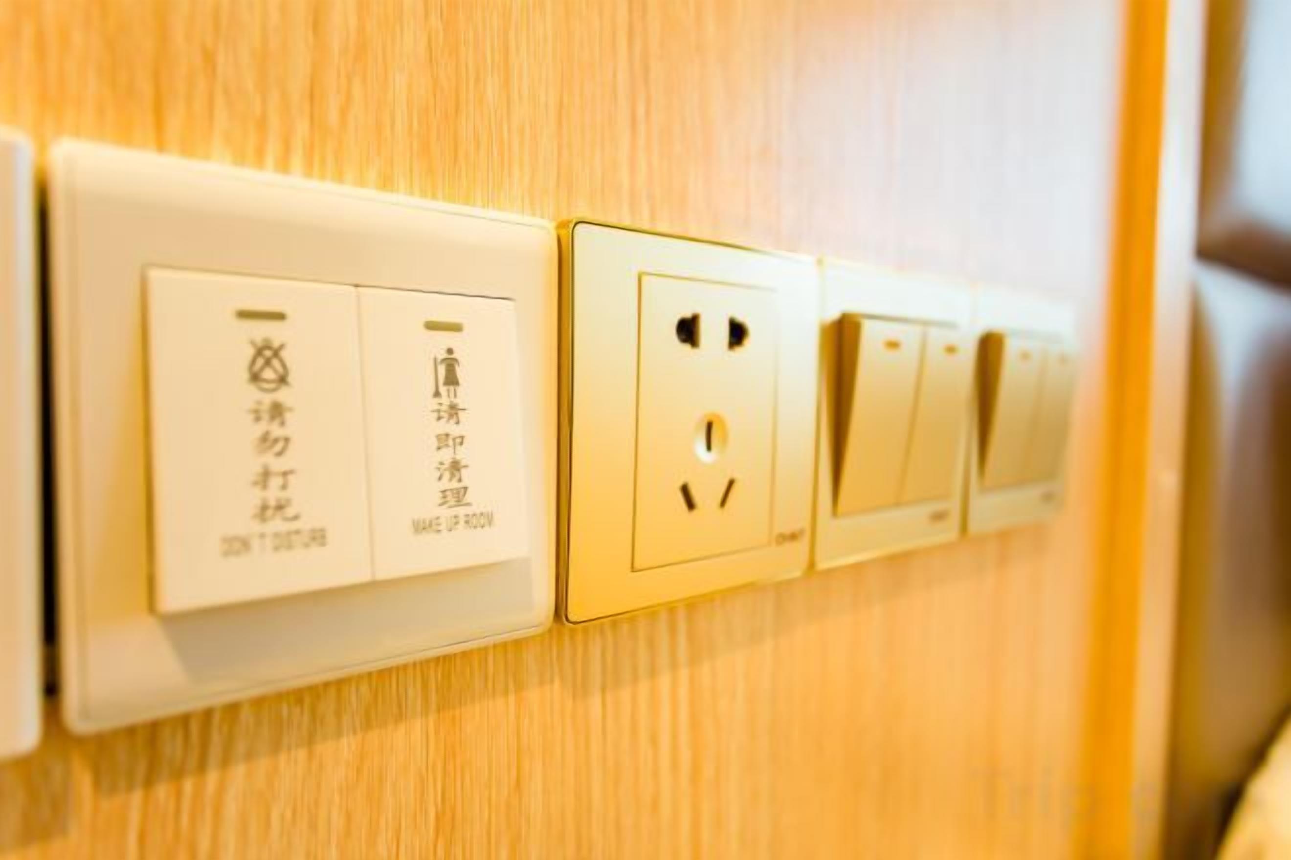 A wall-mounted electrical outlet with a switch and a socket.