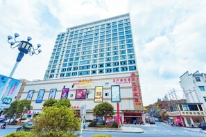 A multi-story hotel with a prominent facade, large windows, and a flat roof. - Anmen Lijiang Inn (Qimen)