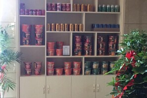 A shelf with various canned goods and a potted plant. - Anmen Lijiang Inn (Qimen)