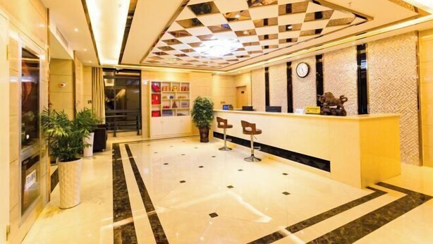 A hotel lobby with a reception desk, seating area, and a check-in counter. - Anmen Lijiang Inn (Qimen)