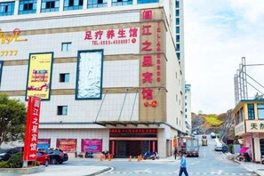 A multi-story building with signage for a health and wellness center, a visible entrance, and a street with vehicles and pedestrians. - Anmen Lijiang Inn (Qimen)
