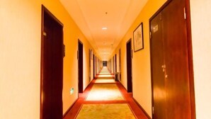 A hotel hallway with doors on both sides and a carpeted floor. - Anmen Lijiang Inn (Qimen)